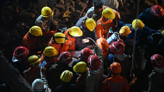 NDRF personnel rescue a survivor trapped under the debris after a building collapsed at the Rohini Sector 16 area, in New Delhi on Wednesday. NDRF personnel rescue a survivor trapped under the debris after a building collapsed at the Rohini Sector 16 area, in New Delhi on Wednesday.