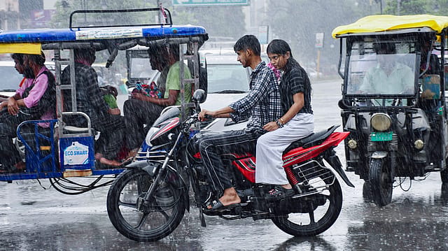 Commuters make their way through a rain-slicked road amid heavy rainfall, in Prayagraj on Thursday. Commuters make their way through a rain-slicked road amid heavy rainfall, in Prayagraj on Thursday.