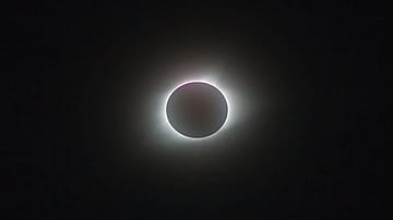 A total solar eclipse occurs when the Moon passes directly between Earth and the Sun, completely covering the Sun's disc for observers along a narrow path on Earth